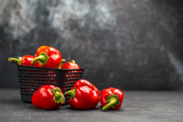 Free photo front view red bell-peppers spicy vegetables on the dark background