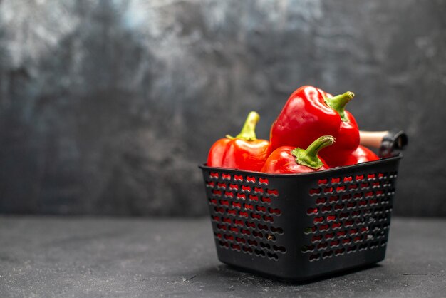 Front view red bell-peppers spicy vegetables on dark desk