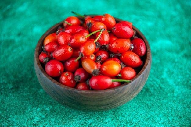 Front view red berries inside plate on green background berry wild fruit health  color