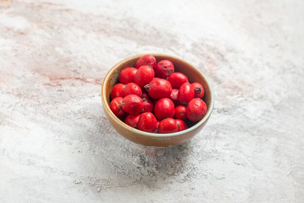 Вид спереди красные ягоды внутри тарелки на белом фоне