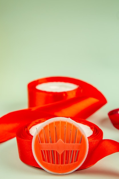 Free photo front view red bow with needles on green background