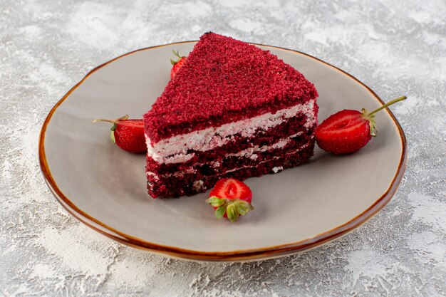 Вид спереди кусочек красного торта кусок фруктового торта внутри тарелки со свежей клубникой на сером