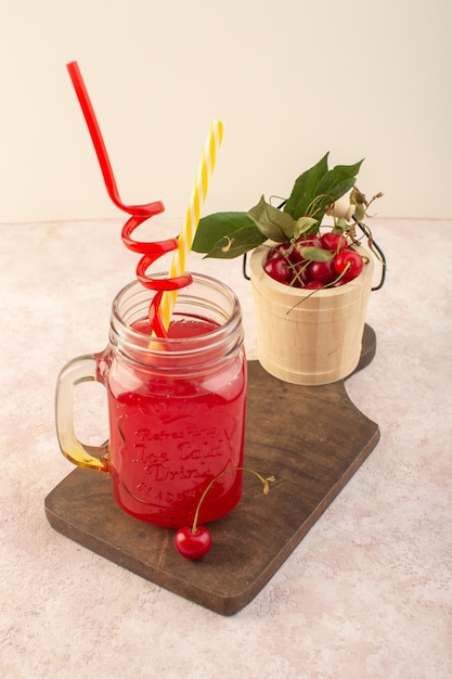 A front view red cherry cocktail with straws and cherries on the pink desk fruit color drink juice