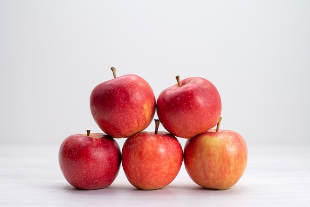 Foto gratuita mele fresche rosse di vista frontale allineate sulla pianta dell'albero maturo pastoso fresco della frutta bianca dello scrittorio