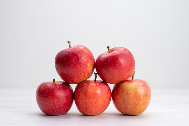 Front view red fresh apples lined on white desk fruit fresh mellow ripe tree plant