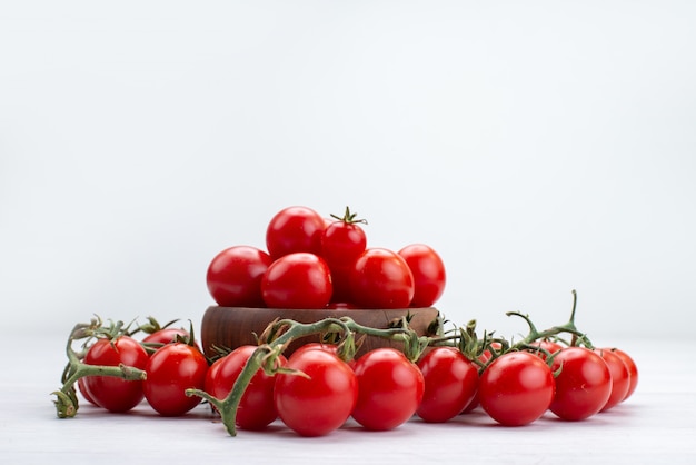Вид спереди красные свежие помидоры, выложенные на белой овощной пище, сырой свежести