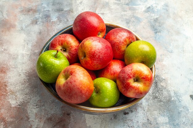 누드 배경에 그릇에 전면 보기 빨강 및 녹색 사과