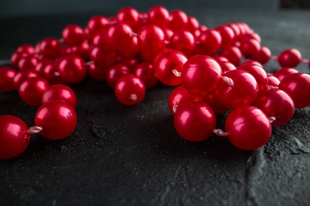 Front view red necklace on dark background color photo fruit berry