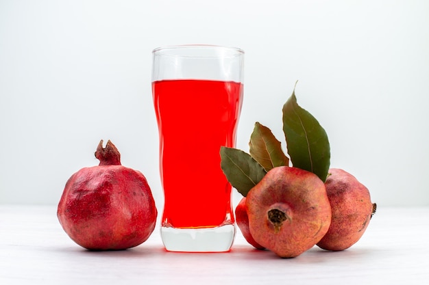 Free photo front view red pomegranate juice with fresh pomegranates on white surface