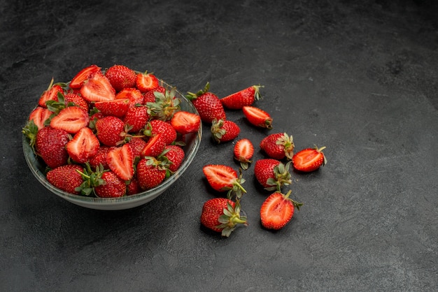 Front view red strawberries sliced and whole fruits on grey background summer color wild tree  juice berry