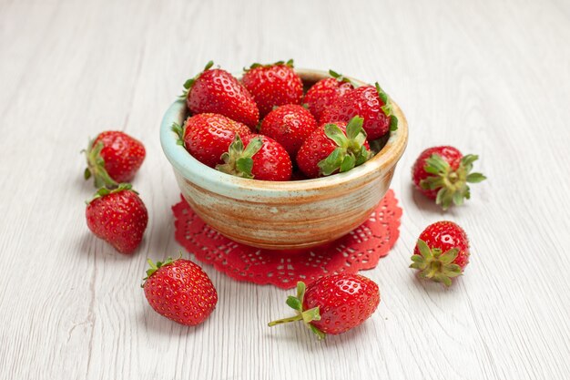 Вид спереди красная клубника на белом столе красного цвета фруктовые ягоды свежие