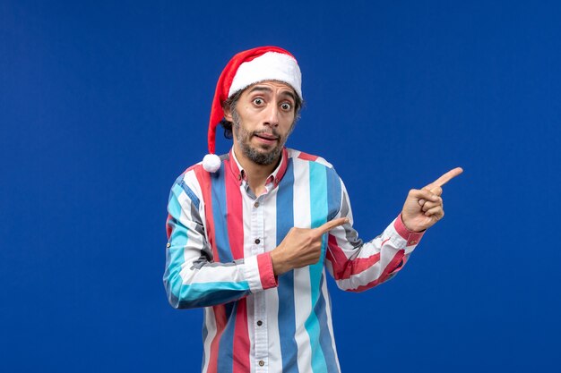 Front view regular male with red christmas cap on blue floor santa holiday christmas