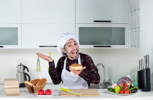 Foto gratuita vista frontale dello chef maschio esultante che tiene il pane