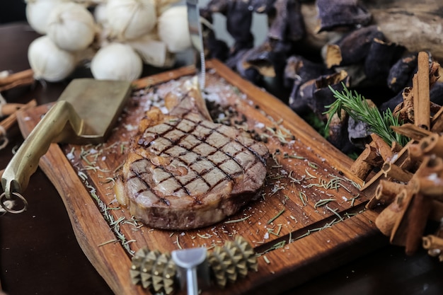 Front view rib steak with garlic cinnamon and an ax on a stand