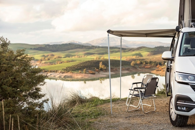 Foto gratuita vista frontale della macchina di viaggio su strada vicino al lago