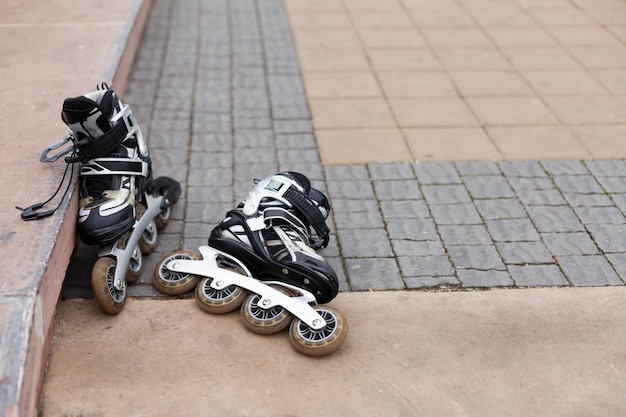 Front view of roller blades on pavement with copy space