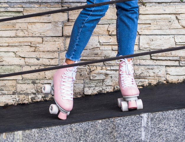 Front view of roller skates on woman behind handrail