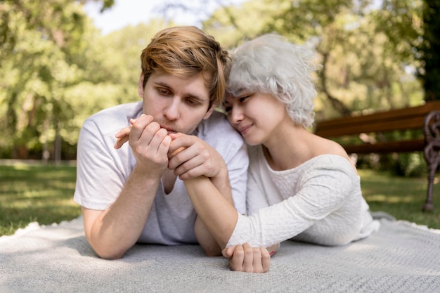 Front view of romantic couple outdoors on a blanket