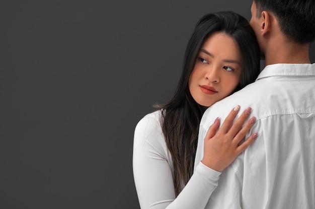 Free photo front view romantic couple posing in studio