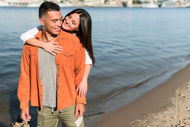 Front view of romantic couple posing together at the beach