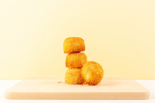 A front view round delicious cakes sweet tasty round formed bakes isolated on the cream colored background sweet sugar confectionery