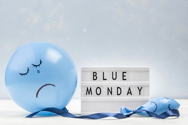 Front view of sad balloon with light box for blue monday