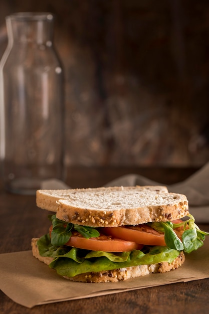 Front view of sandwich with greens and tomatoes