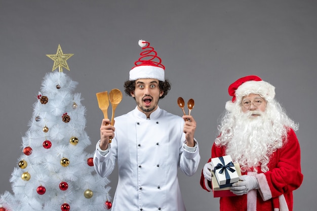 Front view santa claus around holiday attributes with male cook