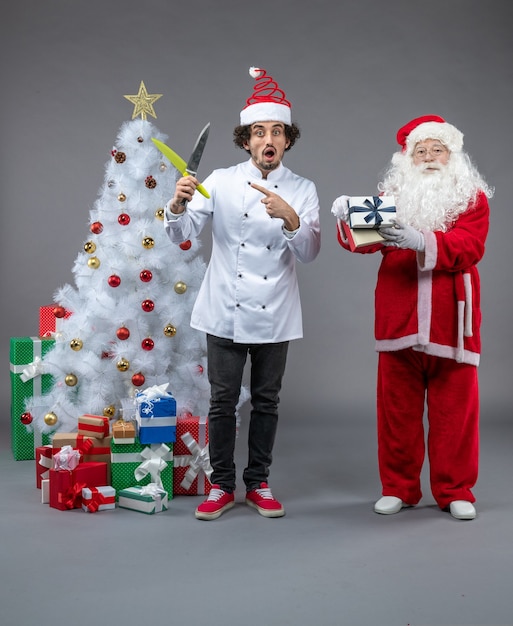 Front view santa claus around holiday presents with male cook