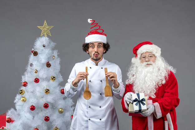 Front view santa claus around holiday tree with male cook