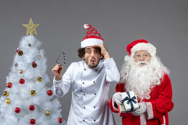 Front view santa claus around holiday tree with male cook