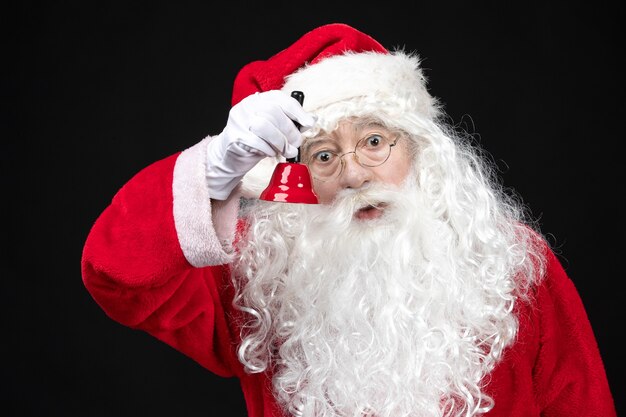 Front view santa claus in classic red suit holding bell