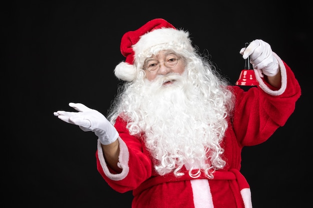 Free photo front view santa claus in classic red suit holding bell