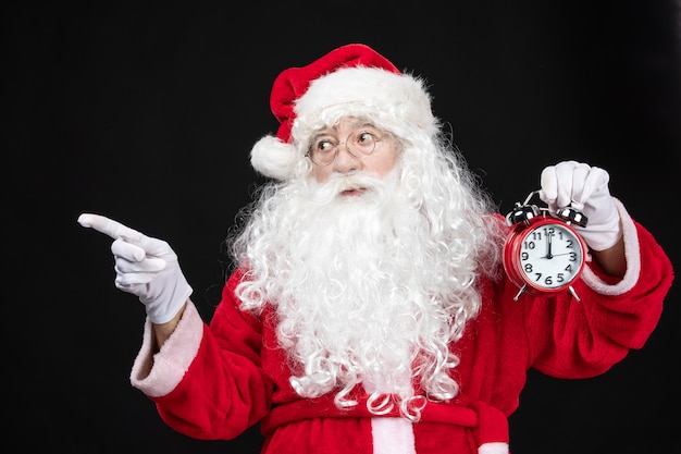시계를 들고 고전적인 빨간 양복에 전면 보기 산타 클로스
