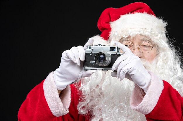 카메라와 함께 사진을 찍는 고전적인 빨간 양복에 전면보기 산타 클로스
