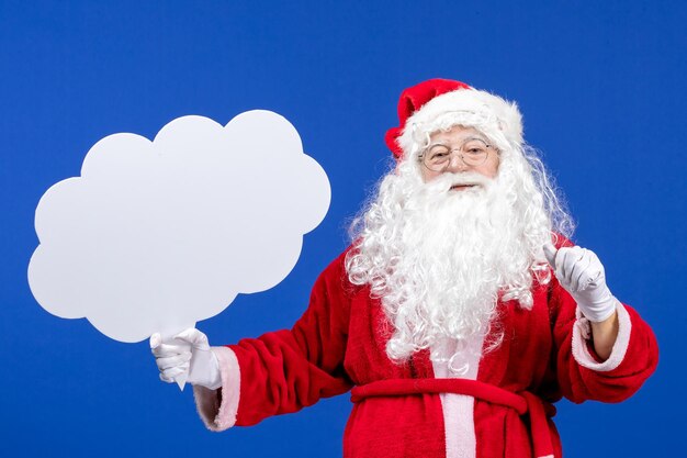 Front view santa claus holding big cloud shaped sign on blue snow color christmas holiday