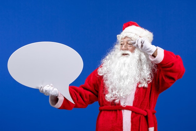 Free photo front view santa claus holding big white sign on the blue color snow holiday christmas