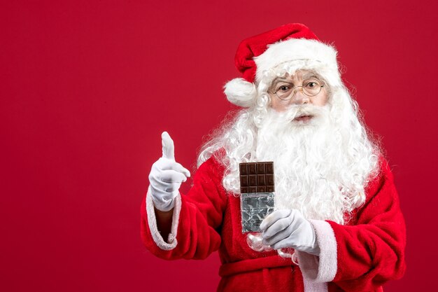 초콜릿 바를 들고 전면 보기 산타 클로스