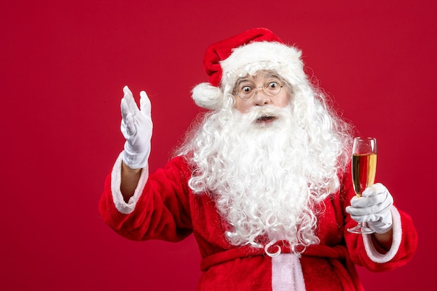 Free photo front view santa claus holding glass of champagne