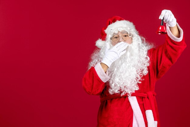 Вид спереди санта-клауса с колокольчиком на красном подарке эмоции рождественские праздники новый год