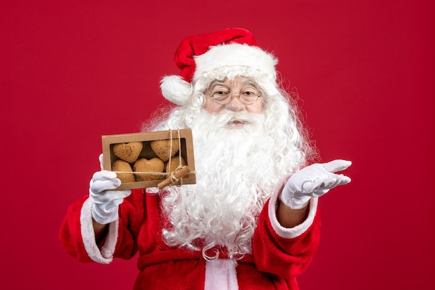 Front view santa claus holding package with biscuits