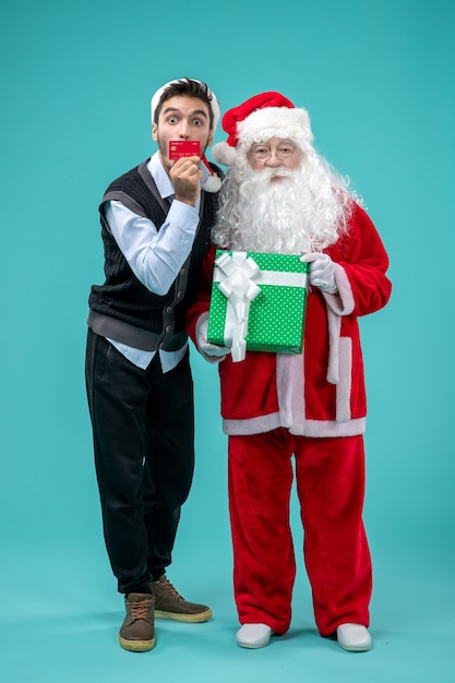 Vista frontale babbo natale che tiene presente con giovane maschio