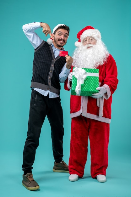 Free photo front view santa claus holding present with young male