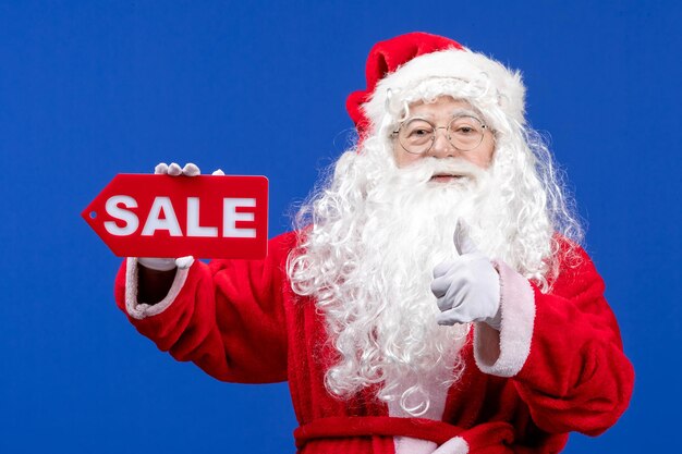 Front view santa claus holding red sale writing on blue color snow holidays new year christmas