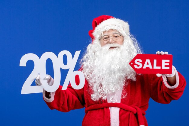 Front view santa claus holding sale and writings on blue color snow holiday new year christmas