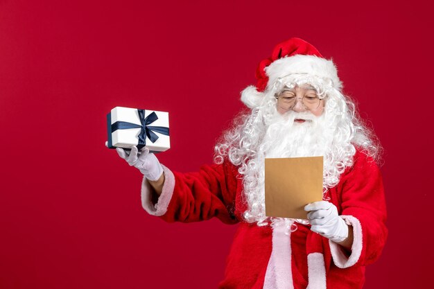 전면 보기 산타 클로스는 아이의 편지를 읽고 빨간 감정 선물 크리스마스 휴일에 선물을 들고