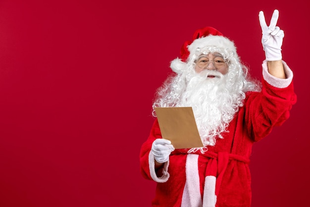 Front view santa claus reading letter from kid on red emotions present xmas holiday