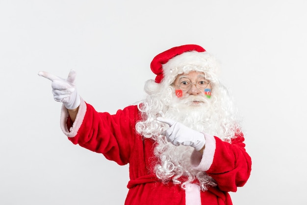 Front view of santa claus with azerbaijani flag paint on his face posing on white wall