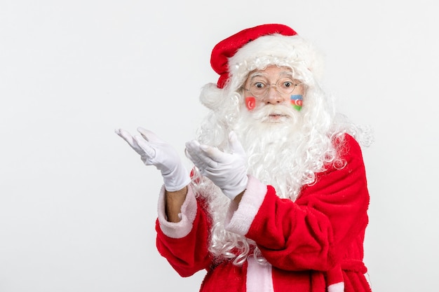 Front view of santa claus with azerbaijani flag paint on his face on white wall