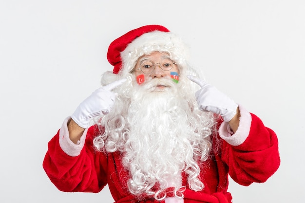 Front view of santa claus with azerbaijani and turkish flag paints on his face on white wall